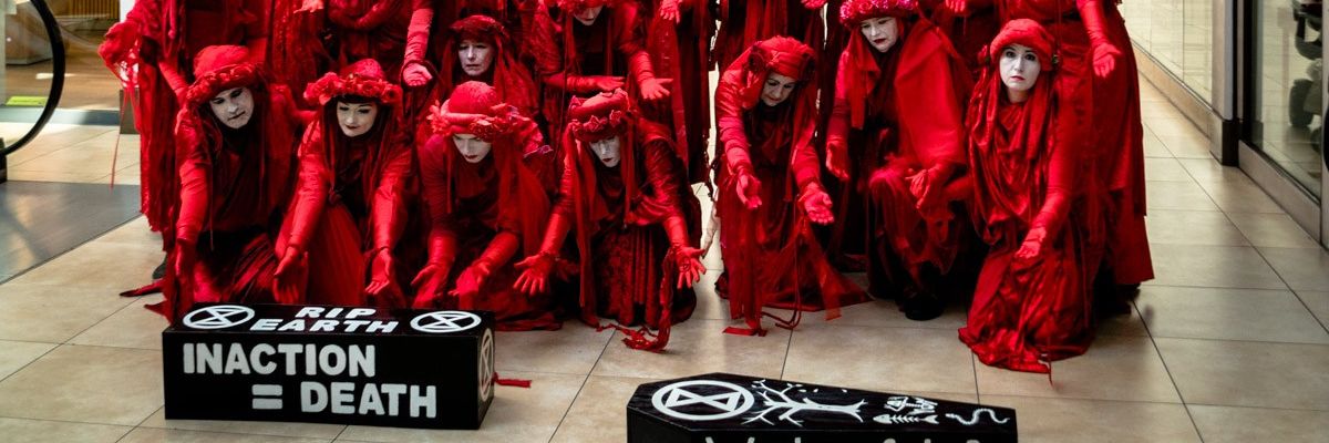 Members of the "Red Rebel Brigade" led a procession around Cambridge, England as part of a funeral for the Paris agreement's 1.5°C temperature target 