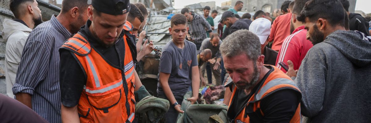 ​Palestinian rescuers remove the body of a victim